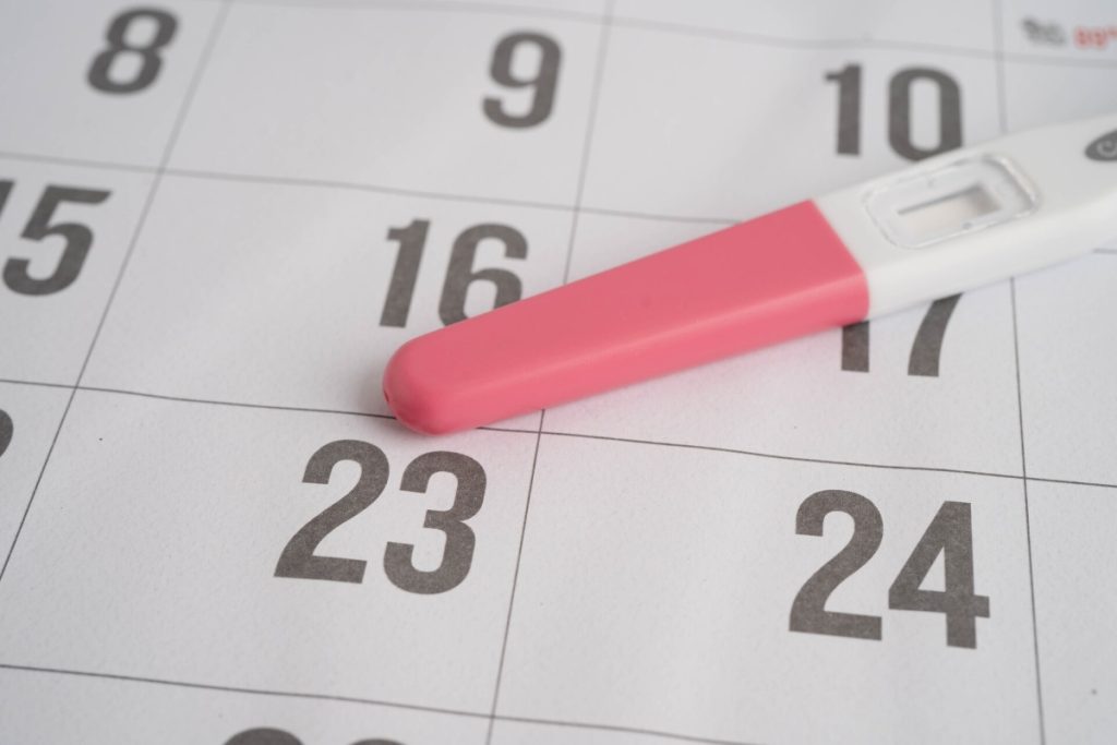 ovulation test kit on top of a calendar