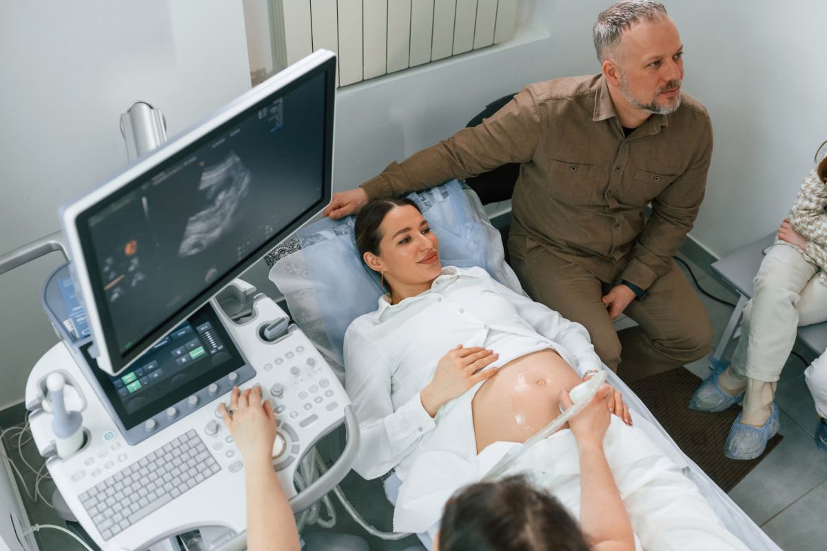 Gender Scan What to Know Before Booking Pregnant woman is lying down in the hospital, doctor does ultrasound