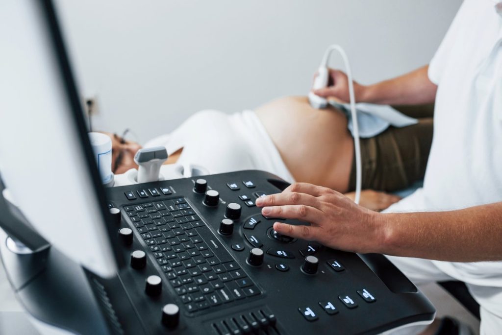 Male doctor does ultrasound for a pregnant woman in the hospital
